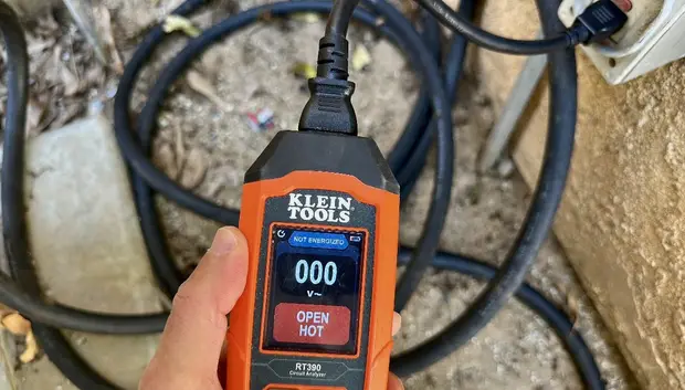 Inspector testing an outlet with a circuit tester