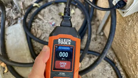 Inspector testing an outlet with a circuit tester